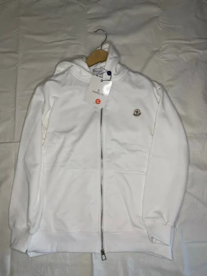 Vit hoodie med dragkedja från Moncler - Helt ny hoodie! Säljes för endast 419:- men bud tas emot!! Storlek M. Vid frågor eller annat så är det bara att höra av sig :)