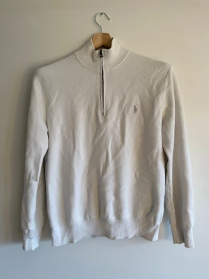 Polo Ralph Lauren - White Quarter Zip - Polo Ralph Lauren quarter-zip i vit waffle-textur, stl M/S. Diskret pony-emblem, silver dragkedja. Ren colorway som funkar året om. Skick: mycket bra
