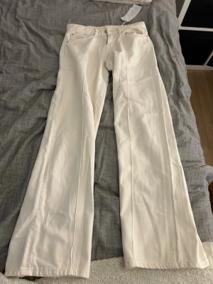 Vida vita jeans med låg midja - Säljer ett par snygga vita jeans med låg midja och vida ben. Köpt från Gina tricot i storlek 32, aldrig använd. Är 163 cm
