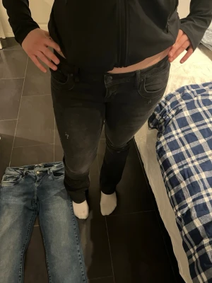Svarta slim fit jeans - Säljer ett par svarta slim fit jeans med klassisk femficksdesign och dragkedjegylf. Jeansen har en något urtvättad look och raka ben. Perfekta för dig som gillar en stilren och enkel vardagsstil.