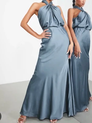Balklänning från asos - Snygg blå långklänning i glansigt satinmaterial med halterneck och draperad överdel. Klänningen har en elegant, figurnära passform och är ärmlös, perfekt för speciella tillfällen. Stilren och modern design som ger en lyxig känsla.