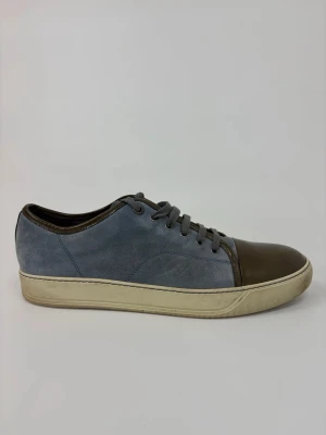 Blå och bruna Lanvin sneakers i mocka och läder - Snygga sneakers med blå mocka på sidorna och brunt läder på tån och runt snörningen. Skorna har vita sulor och klassisk låg profil. Perfekta för dig som vill ha en stilren men unik look.