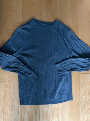 Grå kabelstickad tröja - Säljer en grå kabelstickad tröja i mycket fint skick, knappt använd. Storlek L men passar även M!