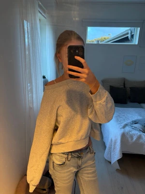 Grå croppad sweatshirt - Säljer en grå croppad sweatshirt med breda ärmar och avslappnad passform. Tröjan har en rund halsringning och är gjord i mjukt bomullsmaterial. 