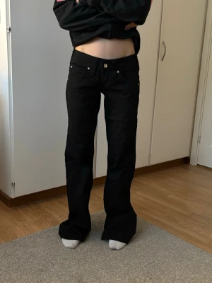 True Religion jeans - Supersnygga vintage svarta true religion jeans. Midjemått: 35cm, innebenslängs: 81cm. Köpta här på vinted för 1000kr. En liten defekt på knät men inget man tänker på (bild 5)💗  • made in US • 100% äkthet • diamantdetaljer • bootcut • low waist