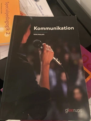 Kommunikation av Tove Phillips - Kurslitteratur i kommunikation, andra upplagan av Tove Phillips. Boken har ett svart omslag med en person som håller mikrofon inför publik. Perfekt för gymnasiet eller högskolan inom samhällsämnen.