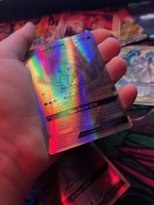 Pokémon holografiska samlarkort - Säljer två Pokémon holografiska samlarkort: Tapu Fini GX och Orbeetle VMAX. Båda korten har färgstark regnbågseffekt och detaljerad design. Perfekt för dig som vill utöka din samling med unika och snygga kort.