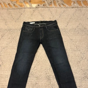 Mörkblå jeans från Nudie Jeans - Snygga mörkblå jeans från Nudie Jeans med klassisk femficksmodell och kontrastsömmar. Jeansen har raka ben och subtila detaljer på bakfickorna. Tillverkade i kraftig denim som ger en tidlös look. Nästan aldrig använda storlek w32 l32