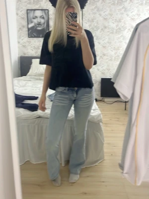 Ljusblå bootcut jeans - Säljer ett par ljusblå bootcut jeans med klassisk femficksdesign och hög midja. Jeansen har en avslappnad passform och är tillverkade i denim med lätt tvättad look. Perfekta för dig som gillar en trendig och bekväm stil.