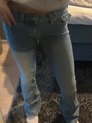 True Religion Joey Low Rise Flare jeans - Snygga ljusblå jeans från True Religion, modell Joey Low Rise Flare. Jeansen har låg midja och utsvängda ben. De är i storlek w26 som motsvarar storlek 36 eller S. 