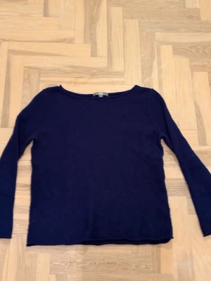 Mörkblå stickad tröja - En enkel och stilren mörkblå stickad tröja med rund halsringning och långa ärmar. Perfekt basplagg att matcha med jeans eller kjol. Tröjan har en mjuk och bekväm känsla, och passar till många olika stilar.