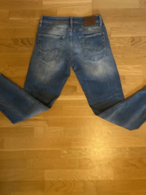 Blå raka jeans från Jack and Jones  - Blåa och raka jeans från Jack and Jones  fläckar vid bakfickorna. 30 i midja och 30 i längd 