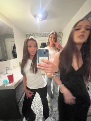 Svarta bootcut byxor - Säljer ett par svarta bootcut byxor med normal passning. Byxorna har en klassisk form som är lite utsvängd nedtill och passar perfekt till en avslappnad och trendig look. Materialet är mjukt och bekvämt, troligen bomull eller polyester.