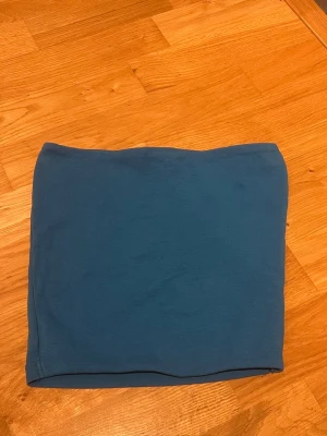 Blå tubtopp från Zara - En stilren blå tubtopp från Zara i mjukt och stretchigt material. Toppen är axelbandslös och har en enkel, clean design som passar perfekt till jeans eller kjol. Perfekt för dig som gillar minimalistiska plagg med snygg passform.