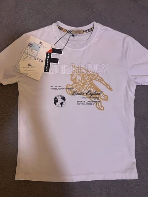 Burberry tshirt med tryck  - ❌Inte äkta ✅Helt ny   ✅Kvitto 🧾 inkluderad.  95% bomull 5% polyster. Fråga gärna vad som helst om plagget Den sitter XS.