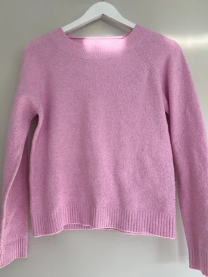 Ljusrosa stickad tröja ifrån Vero Moda  - Säljer denna ljusrosa stickade tröjan i storlek S med rund halsringning och långa ärmar. Tröjan har ribbade muddar vid ärmarna och nederkant, tröjan kan vara lite nopprig men inte något jag själv tänker på. 