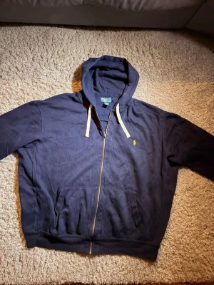 Mörkblå hoodie från Polo Ralph Lauren - Säljes med fläckar, går säkert bort i tvätt med fläck medel. Större storlek. Skriv ett meddelande vid frågor