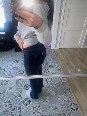 Mörkblå mjukisbyxor med fickor - Säljer ett par mörkblå mjukisbyxor med raka ben och stora fickor både fram och bak. Byxorna har dragsko i midjan och är tillverkade i ett mjukt och stretchigt material som passar perfekt för chill dagar. Snygg och enkel design som är lätt att matcha.