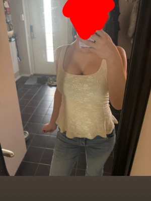 Ljusgul blommig linnetopp - Söt ljusgul linnetopp med blommigt mönster och lätt utsvängd nederkant. Toppen är ärmlös och har breda axelband, perfekt för varma dagar. Materialet känns mjukt och luftigt, vilket gör den superbekväm att bära.