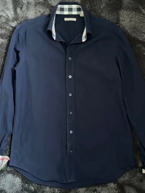 Burberry skjorta  - Super fin marinblå burberry skjorta i storlek M inga defekter, tags finns kvar och finns även QR kod i skjortan. Nypris 5000kr mitt pris endast 999kr. Hör av er vid frågor. Mvh Luxery closet😊🙌