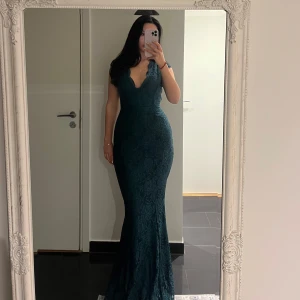 Mörkgrön långklänning med spets - Elegant mörkgrön spetsmönstrad långklänning med djup v-ringning och öppen rygg. Storlek 40❣️