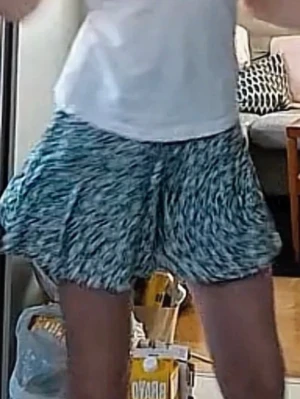 Blommig kortkjol från Zara - Supersöt kortkjol från zara med blommigt mönster i turkost, vitt och svart. Kjolen har en elastisk midja och är gjord i ett lätt och luftigt material, perfekt för varma dagar. Passar perfekt till en enkel t-shirt eller linne. Liten fläck på baksidan och lite sliten på snöret, inget märkvärdigt. 