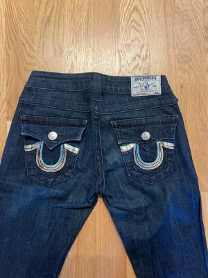 Mörkblå True Religion jeans - Snygga mörkblå jeans från True Religion med raka ben och skitsnygga glittriga fickor!! Lågmidjade i storlek 25🥰🥰