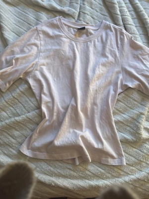 Ljusrosa basic t-shirt i bomull - En enkel och stilren ljusrosa t-shirt med rund hals och korta ärmar. Tillverkad i mjuk bomull som känns skön mot huden. Perfekt att matcha med jeans eller kjol för en clean look.