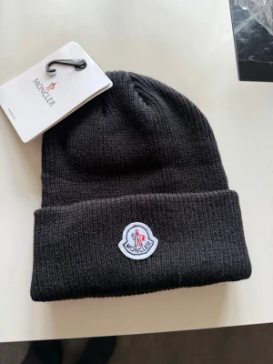 Svart mössa - 100% bomull, oanvänd. Pris kan diskuteras