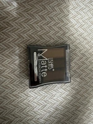 Ushas Matte ögonbrynspalett 3 färger - Ögonbrynspalett från Ushas med tre matta nyanser i bruna toner. Kommer i en kompakt plastförpackning med genomskinligt lock. Perfekt för att forma och fylla i brynen med naturligt resultat. Pudret är lätt att applicera och blanda.