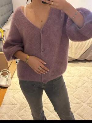  kofta med knappar i färgen lils - Lila kofta med korta ballong armar