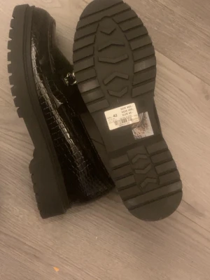 Svarta loafers med kedjedetalj - Eleganta skor, passar till vardags och fest, aldrig använda storlek 42, original pris 450 säljer dem för 200 vid snabbt köp 