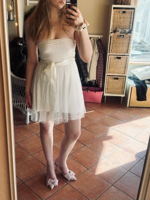 Studentklänning  - Söt vit axelbandslös kortklänning med prickigt mönster och volangig kjol från Ida Sjöstedt. Perfekt för studenten💕