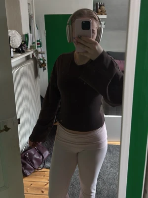 Brun topp med knyt i ryggen - Säljer en brun långärmad topp med snygg knytning i ryggen. Toppen har en tight passform och är perfekt för dig som gillar trendiga detaljer. Passar till både jeans och kjol för en cool look. Aldrig använd 