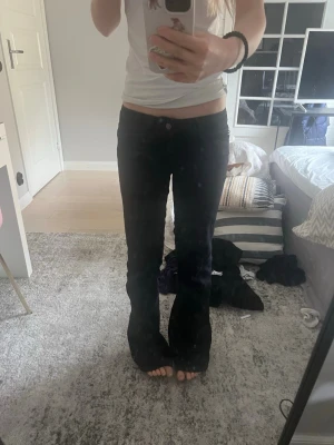 Svarta bootcut jeans från Cheap Monday - Säljer ett par svarta bootcut jeans från Cheap Monday med låg midja och en lila patch bak. Jeansen har klassisk femficksdesign. Säljer då av jag inte använder dom längre. Dom är i nästan nytt skick. Dom nuddar marken är 164. 