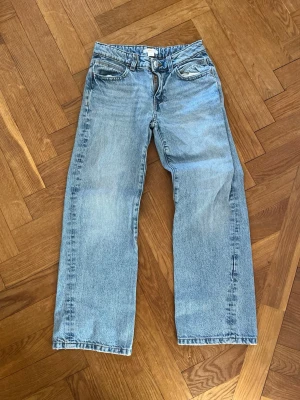 Ljusblå raka jeans från Monki - Säljer ett par ljusblåa baggy jeans från Gina Tricot i storlek 146. Har små paljetter på fickorna. 