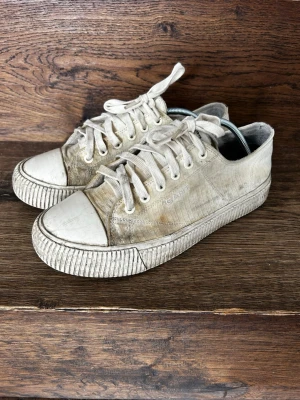 Gant Sneakers *42* - Klassiska vita sneakers från Gant med lågt skaft och rund tå. Skorna har vita snören, gummisula och ovandel i textil. Diskret Gant-logga på sidan. Perfekta för en avslappnad och stilren look.