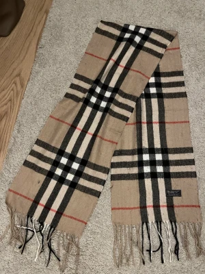 Burberry scarf - Jag säljer en modern burberry scarf som passar bra till många outfits. Kvaliteten är 8,5/10 och nypris är 4500-5000. Riktigt bra pris för en sådan fin scarf!