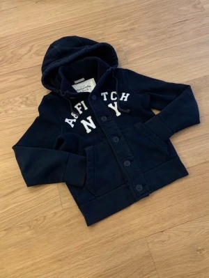 Abercrombie & Fitch Cardigan - Säljer en sjukt snygg Abercrombie & Fitch Cardigan. Denna är sjukt eftertraktad och väldigt grisch och archive. Storleken är S. Skicket 10/10. Priset kommer vara 999kr men kan sänkas.