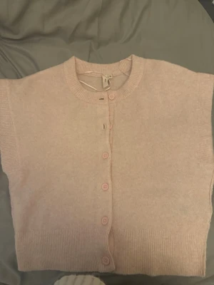 Ljusrosa kortärmad kofta - Supersöt ljusrosa kofta med korta ärmar och rund hals. Perfekt att slänga över en topp eller ha själv💞