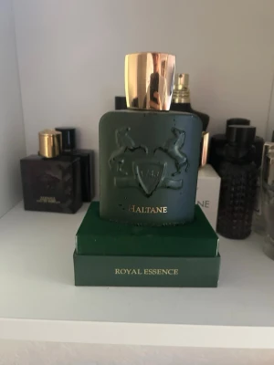 Parfums de Marly Haltane parfym - Lyxig parfymflaska från Parfums de Marly, modell Haltane. Det är garanterat mer än halva kvar om jag skakar den så skulle jag uppskatta mellan 80-90 ml kvar av 125 ml, därmed rätt mycket kvar || box medföljer och självklart är parfymen äkta || håller hur länge som helst på huden då det är en oud doft || luktar extremt gott och unikt faktiskt, sjukt underskattad || det ska sitta en sak under atomizern, den har tyvärr fastnat i locket, ingenting som påverkar parfymen däremot || frågor?