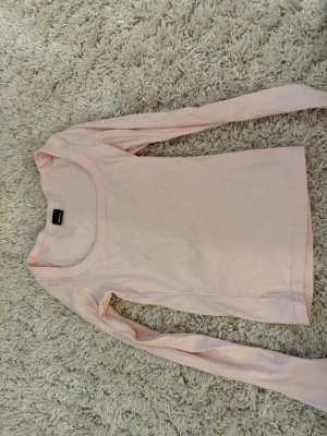 Ljusrosa långärmad topp Gina Tricot - Supersöt ljusrosa långärmad topp från Gina Tricot. Toppen är ribbad och har en rund halsringning. Perfekt att styla med jeans eller kjol för en enkel och fräsch look.