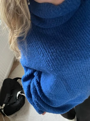Blå stickad polotröja från Zara - Mysig blå oversize stickad polotröja från Zara med grov ribbstickning. Tröjan har hög krage och långa ärmar, perfekt för kyliga dagar. Enkel och stilren design som är lätt att matcha med olika outfits.