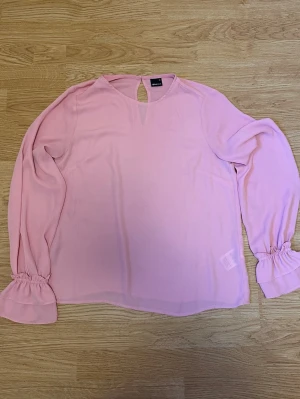 Ljusrosa blus med volangärm - Ljusrosa blus från Gina Tricot med volangdetalj vid ärmslut. Strl 36
