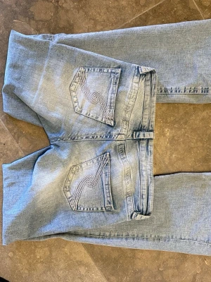 Low waist bootcut jeans Gina Young 14+ - ✨ Säljer ett par superfina low waist bootcut jeans från Gina Young 14+ i storlek S! Jeansen har en snygg ljusblå tvätt och den klassiska bootcut-modellen som sitter tajt över benen och blir lite utsvängda längst ner 🤍 De är i bra men använt skick och fortfarande jättesnygga att styla till både vardag och Y2K-inspirerade outfits. Fina detaljer på bakfickorna som ger dem extra charm! !obs dem är nötta längst ner vid hälen men är enkelt fixat! Priset är ej hugget i sten så skriv i dm vid frågor!💕