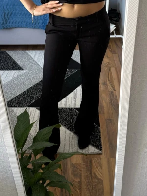  kostymbyxor bikbok - Snygga svarta kostymbyxor med utsvängda ben och hög midja. Klassisk design med hällor för skärp och diskret knappstängning framtill. Perfekta för en stilren och trendig look. Kan gå ner i pris vid snabbt köp