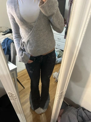 Mörkblå bootcut jeans med detaljer - Snygga mörkblå bootcut jeans med låg midja och slitna detaljer. 
