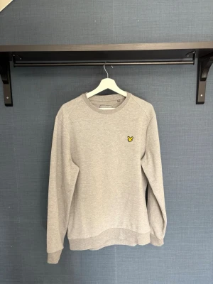 Grå Sweatshirt från Lyle & Scott - Stilren grå Sweatshirt/Crewneck från Lyle & Scott, Välidgt skönt mjukt material, använd ett fåtal gånger
