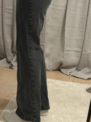 Svarta Raka Jeans BikBok - Snygga svarta raka jeans med klassisk femficksdesign och normalhög midja. Jeansen har en lätt tvättad look och raka ben som blir vidare nedtill. Perfekta för en avslappnad och trendig stil.
