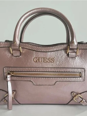 Rosa guess handväska - Jättefin rosa handväska i märket guess. Den är i jättefint skick och har ett avtagbart axelband. Mått 25,5 x 14 x 6 cm.